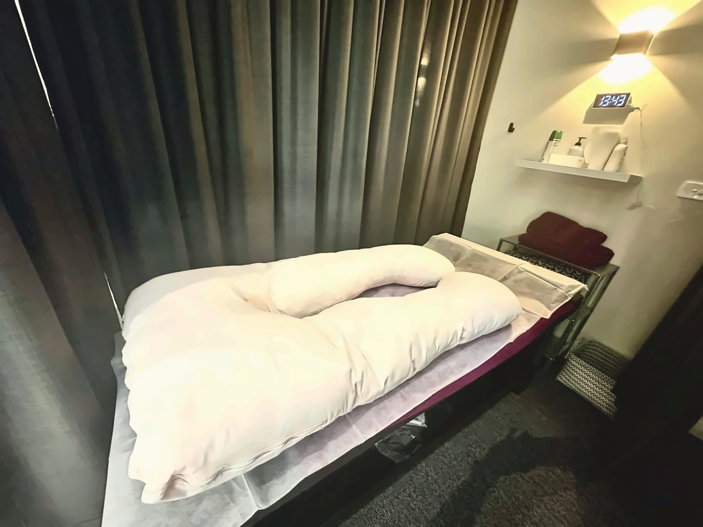 New Concept Massage private treatment room with white pillow setup and ambient lighting