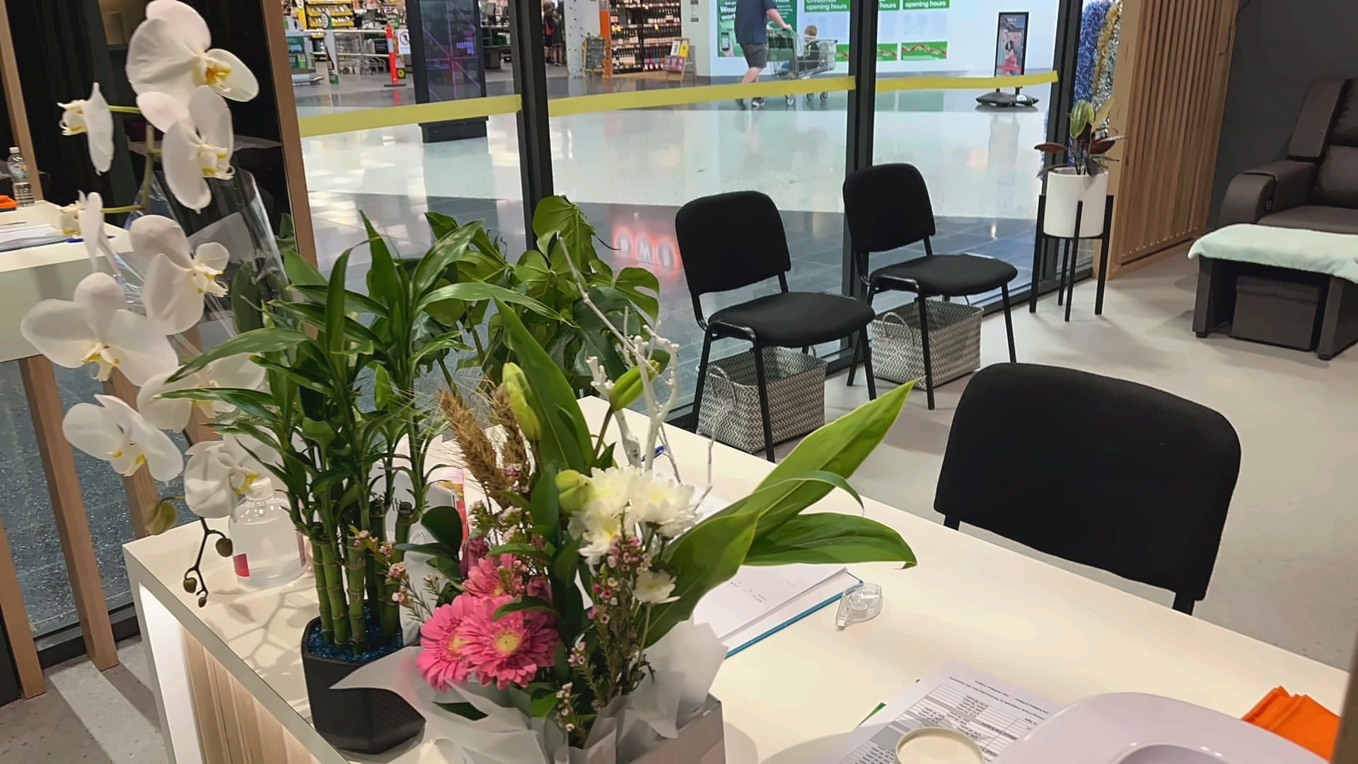 New Concept Massage reception counter with timber panelling, orchids and warm lighting