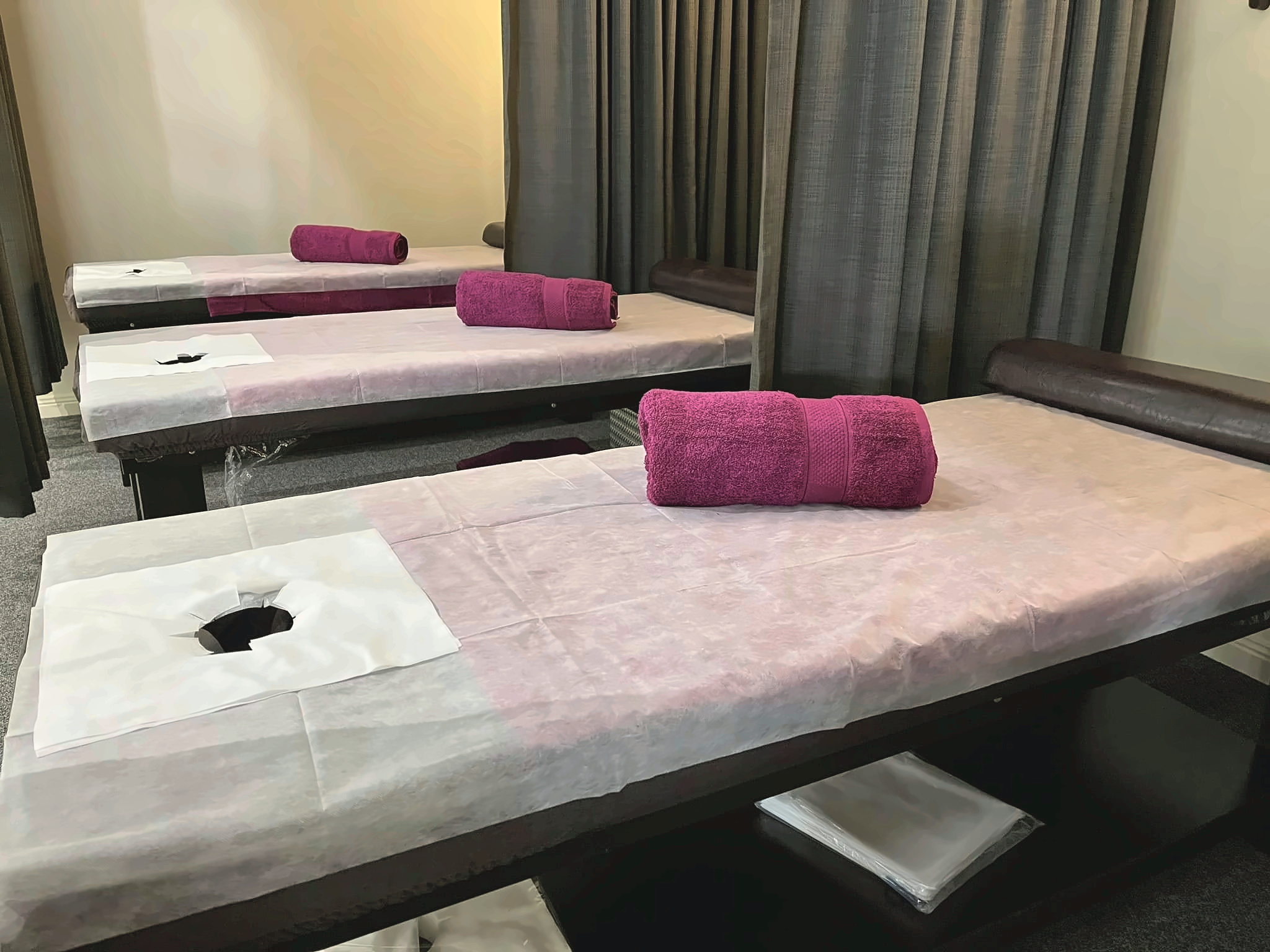 New Concept Massage treatment room with professional massage tables and fresh linen